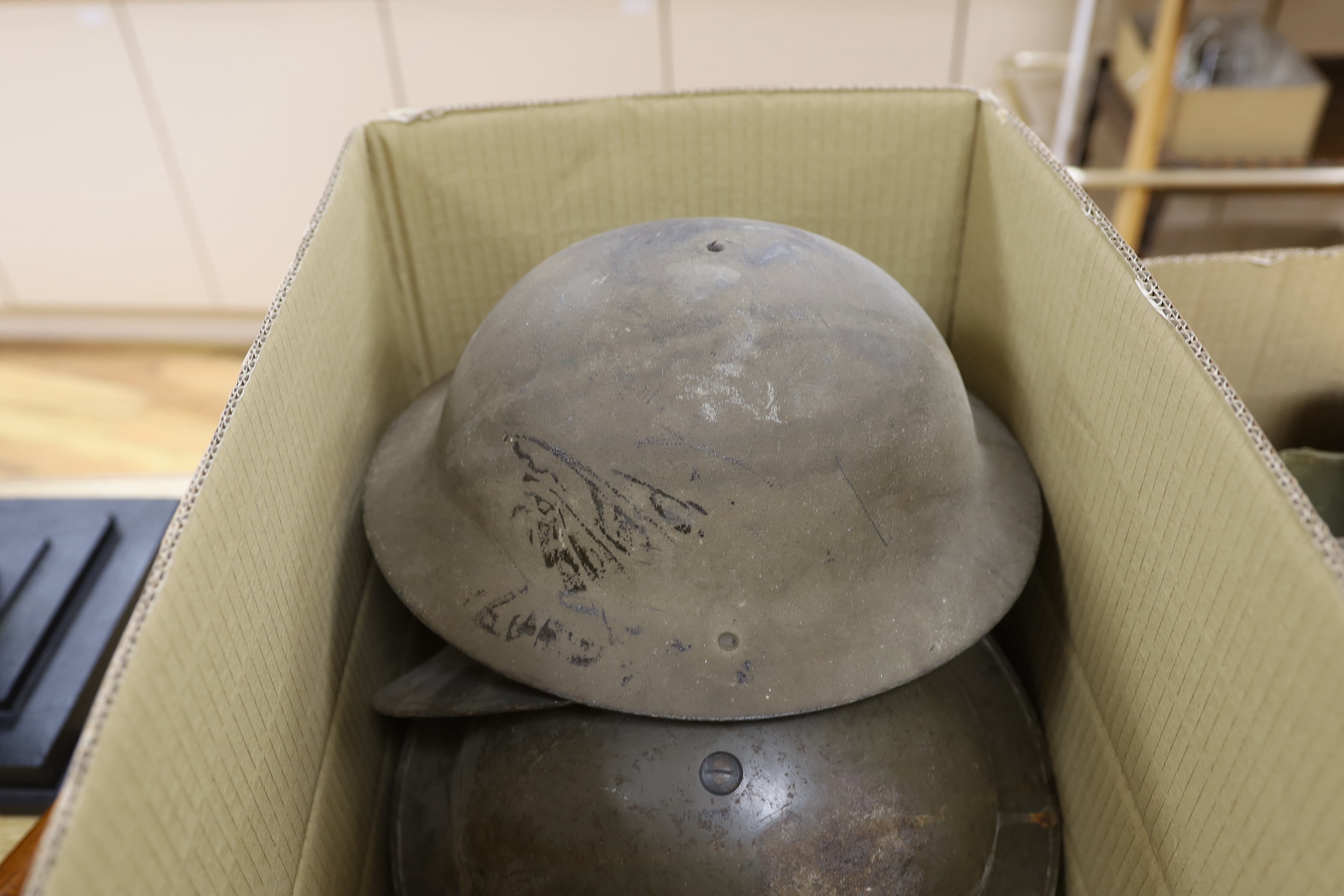 Six military etc. tin helmets. Including an example, painted as an Air Raid Warden’s helmet, with other items, including a military shoulder bag etc.
